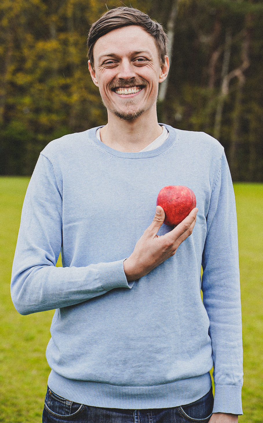 Raphael Fellmer hält sich einen Apfel vors Herz