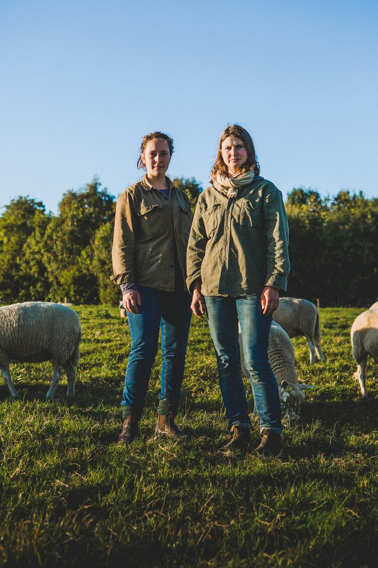 Zwei Frauen stehen auf einer Schafweide