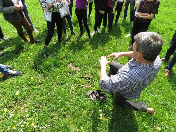 Mann kniet auf Wiese