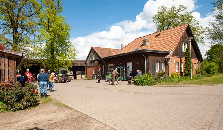 Landwirtschaftliche Gebäude mit einem Hof und Mitarbeiter:innen