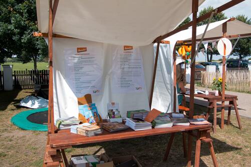 Stand mit Programm der Feier im Freien