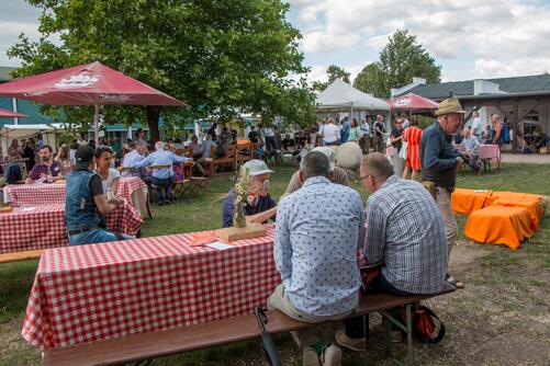 Besucher:innen auf Bänken auf dem Fest