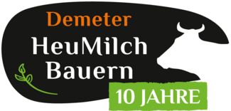 Schriftzug "Demeter HeuMilch Bauern 10 Jahre" mit der Silhouette einer Kuh