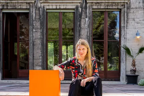 Dr. Kira Vinke mit dem orangen Cube auf einer Treppe