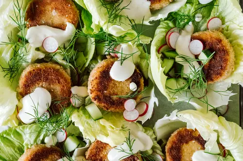 Die Talen sind angerichtet auf Salatblättern, darauf ein Gurken-Radieschen-Dipp