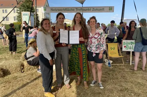 Foto von vier Frauen, die eine Gründungserklärung in der Hand halten